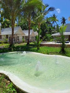 une grande piscine d'eau en face d'une maison dans l'établissement The Palms Penida, à Toyapakeh