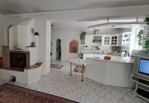 Holiday Villa Loket في لوكت: مطبخ فيه دواليب بيضاء وتلفزيون