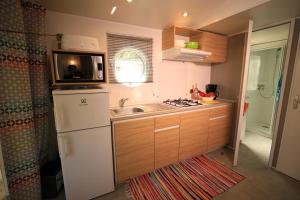 eine kleine Küche mit Spüle und Kühlschrank in der Unterkunft Camping International & Spa 4* in Hyères