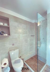 a bathroom with a toilet and a glass shower at Tins Hotel City - Athens in Athens