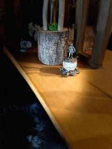 mała figurka siedząca na drewnianym stole w obiekcie Chalet A Baisoara - Cabana A-Frame la munte w mieście Băişoara