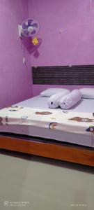 Bett mit weißer Bettwäsche und Kissen in einem Zimmer in der Unterkunft D' pamor Homestay in Halangan