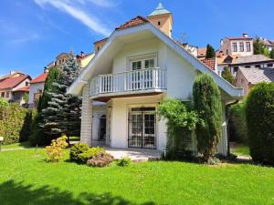 uma casa branca com uma varanda e um quintal em Holiday Villa Loket em Loket