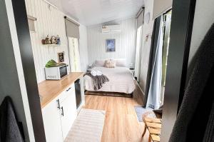 małą sypialnię z łóżkiem w małym domku w obiekcie Binderaga Old Orchard w mieście Bilpin