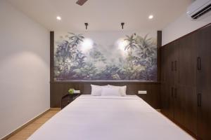 1 dormitorio con 1 cama grande y una pintura en la pared en Reach Homes, en Kochi