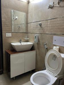 a bathroom with a white toilet and a sink at Divine India Service Apartment 3 BHK D-198 Saket in New Delhi