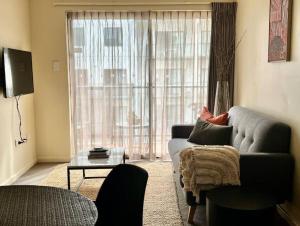 uma sala de estar com um sofá e uma grande janela em Prime Location 1 Bdr Apt in Perth em Perth