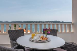 Villa Ana Trogir II في تروغير: طاولة مع طبق من طعام الإفطار على شرفة
