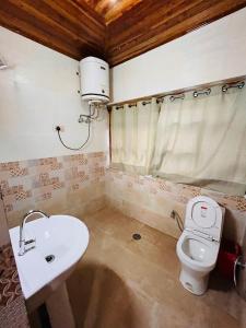 a bathroom with a toilet and a sink at Varsha Guest House in Vapi
