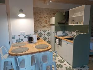 a kitchen with a wooden table and some blue stools at Casa Lehovo in Lechovo