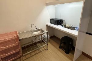 a small kitchen with a sink and a microwave at MYP Cherngtalay in Phuket Town