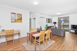 een woonkamer met een tafel en stoelen en een bank bij Executive Apt - 2BR 1BA w Parking in Perth