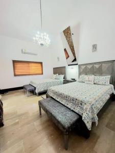 a bedroom with two beds and a chandelier at Lujosa Villa en Casa de Campo Golf & Resort, La Romana Brre#15 in La Romana