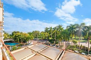 a view of a resort with a pool and palm trees at Idyllic Waterfront Pool Escape with Esplanade View in Darwin
