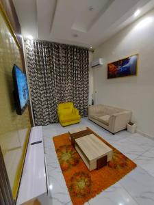 a living room with a couch and a tv at Soulmate Hotels & Suites in Lagos