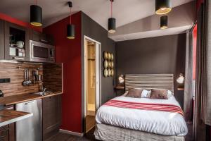 a small bedroom with a bed and a kitchen at Le 84 Sainte-Cath' in Lille
