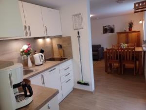 a kitchen with white cabinets and a dining room at FeWo Seeadler - Heuser Prerow in Prerow