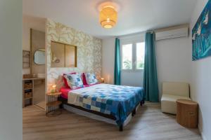 ein Schlafzimmer mit einem Bett, einem Stuhl und einem Fenster in der Unterkunft villa australina in Saint-Paul