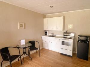 a small kitchen with a table and a stove top oven at Silverwood Motel in Cavendish