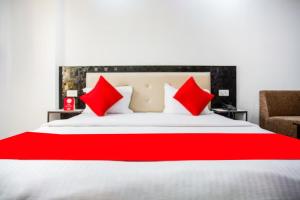 - une chambre avec un grand lit et des oreillers rouges dans l'établissement Hotel Raj Ganga Haridwar Near Raja Ji National park Jeep Safari - Excellent Customer Choice- Best Seller, à Haridwar