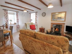 a living room with a couch and a fireplace at Oak Cottage in Appleby