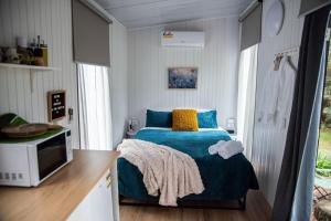Binderaga Pine Forest في Bilpin: غرفة نوم بسرير في غرفة صغيرة