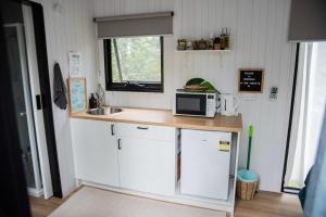 una piccola cucina con bancone e forno a microonde di Binderaga Pine Forest a Bilpin