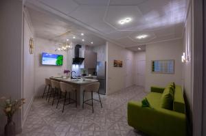 uma cozinha e sala de estar com um sofá verde e uma mesa em Modern Entire Apartments em Colombes