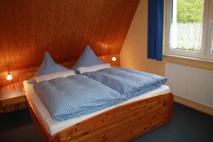 um quarto com uma cama com almofadas azuis e brancas em Ferienhaus Eulennest - Ulenhoef em Prerow