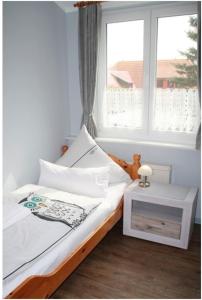 FeWo Waldkauz - Ulenhoef في بريرو: غرفة نوم بسرير مع نافذة وطاولة