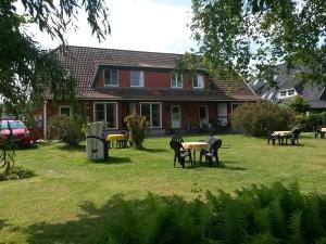 FeWo Waldkauz - Ulenhoef في بريرو: منزل به طاولات وكراسي في الفناء