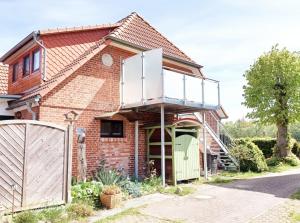 een huis met een balkon erbovenop bij FeWo Erle - Ulenhoef in Prerow
