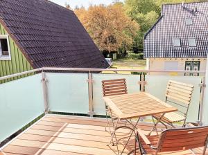 een houten terras met een tafel en stoelen erop bij FeWo Erle - Ulenhoef in Prerow