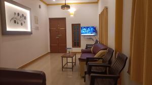 uma sala de estar com um sofá, cadeiras e uma mesa em La Shashalia Luxury em Pondicherry