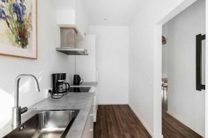 a kitchen with a sink and a counter top at Lovely Apartment At Solgaarden 9 Årsdale in Svaneke +19 photos