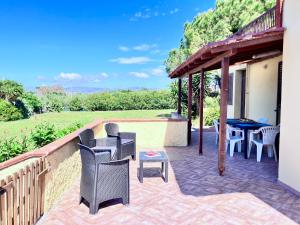 eine Terrasse mit Stühlen und einem Tisch an der Wand in der Unterkunft Portion of villa with garden, about 1km from the beach in Marina di Sorso