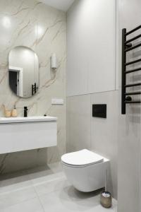 uma casa de banho branca com um WC e um espelho. em Modern Entire Apartments em Colombes
