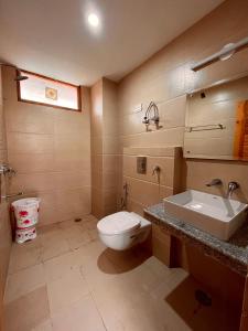a bathroom with a toilet and a sink at Sawdesh hotel in Vapi
