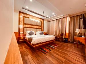 a bedroom with a large bed and a desk at Sawdesh hotel in Vapi