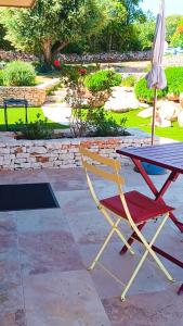 a chair and an umbrella sitting next to a table at Agréable chambre dans le maquis in Bonifacio