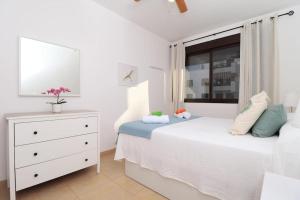 トロクス・コスタにあるEl "Coqueto"のベッドとドレッサーと窓のある寝室