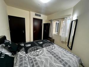 a bedroom with a bed with a black and white comforter at Dubai gate 1, JLT Q cluster in Dubai