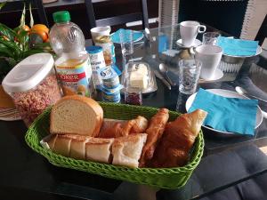 - un panier de pain et de viennoiseries sur une table dans l'établissement 2 Chambres d 'hôtes chez un particulier avec piscine, à Saint-Leu-la-Forêt