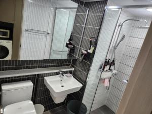 uma casa de banho com um lavatório, um WC e um espelho. em Daegu Dongseongro Star B&B business hotel em Daegu