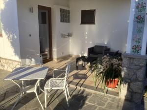 un patio con tavolo, sedie e pianoforte di B&B Casetta Minghitto ad Anacapri