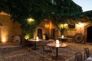 - un patio avec des tables et des chaises dans une cour la nuit dans l'établissement Baglio Siciliamo Country House, à Noto Marina