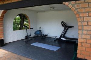 een fitnessruimte met 2 hometrainers en een bakstenen muur bij Spacious 3 bedroom house in Lilayi, Lusaka in Lusaka