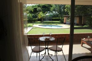 een tafel en stoelen op een patio met een zwembad bij Spacious 3 bedroom house in Lilayi, Lusaka in Lusaka