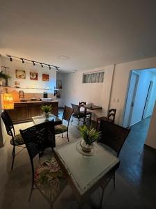 ein Wohnzimmer mit Tischen und Stühlen sowie eine Küche in der Unterkunft Pousada Cristais SUITE 15 in Teófilo Otoni