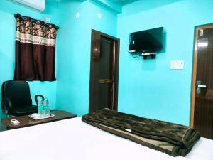 Zimmer mit einem Bett, einem Spiegel und einem TV. in der Unterkunft Hotel Ambika in Deoghar
